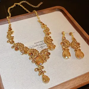 Vintage luxury gold-tone necklace set with amber teardrop rhinestones on linen tray