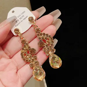 Detailed macro view of vintage gold-tone drop earrings with amber champagne crystals