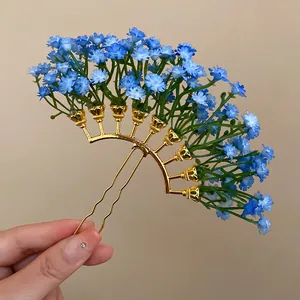 Macro view of an elegant blue gypsophila floral hairpin with a gold-tone U-shaped frame