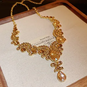 Macro view of vintage teardrop geometric necklace with amber crystals on gold chain