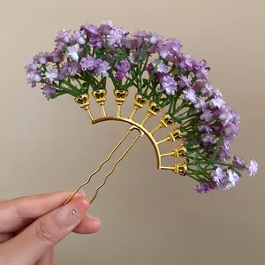 Close-up detail of a golden hair fork with purple baby's breath flower clusters