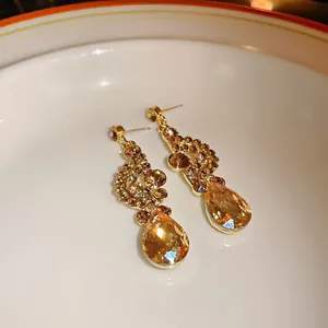 Macro view of vintage gold-tone earrings with faceted amber teardrop crystals
