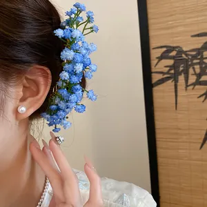 Close-up of elegant blue Baby's Breath floral hair pin worn on female model's hair
