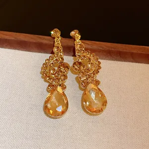 Elegant vintage gold-toned drop earrings featuring sparkling champagne crystal rhinestones.