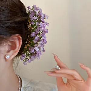 Detailed view of an elegant purple gypsophila baby's breath flower hair fork worn in hair