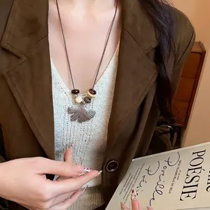 Elegant ginkgo leaf pendant necklace with wooden beads for women's sweater styling