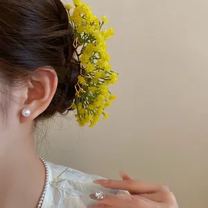 Detailed view of a Mori style floral hairpin with vibrant yellow gypsophila flowers