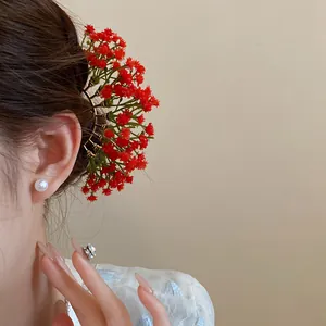 Close-up detail of red baby's breath flower hair fork on an elegant female hairstyle