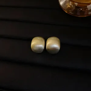 Detailed view of gold brushed texture geometric bean stud earrings