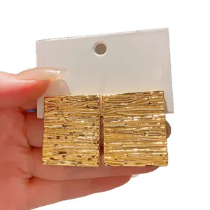 Elegant minimalist gold textured square stud earrings featuring a wrinkled metal finish