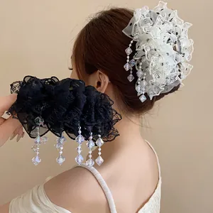 Gros plan sur les volants délicats en dentelle blanche et les pompons en cristal irisé