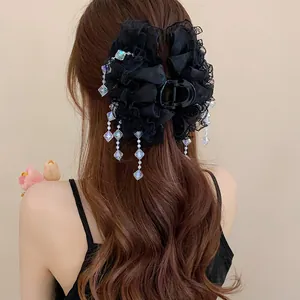 Détail d'une pince à cheveux en dentelle noire avec pampilles de cristal