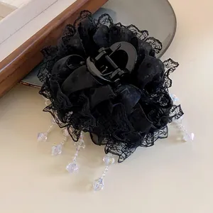 Détail rapproché d'une pince à cheveux en dentelle noire avec perles de cristal élégantes.