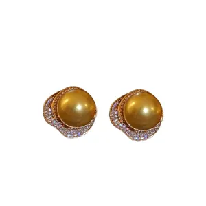 Boucles d'oreilles puces en perles dorées avec détails en zircon sur fond blanc pur