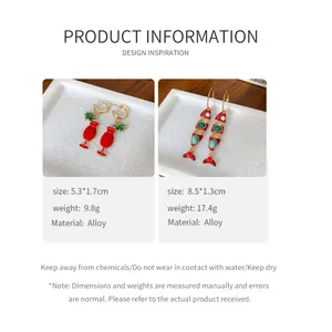 Vue détaillée des boucles d'oreilles en émail rouge verre à cocktail et poisson