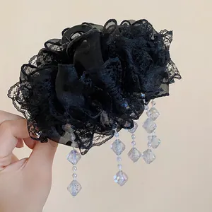Vue détaillée de la dentelle noire élégante et des perles de cristal sur la pince