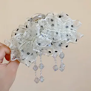 Détail d'une élégante pince à cheveux en dentelle blanche avec perles brillantes