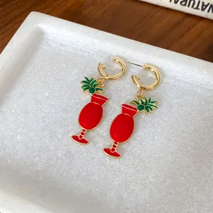 Détail exquis de boucles d'oreilles verre à cocktail tropical en émail rouge et doré