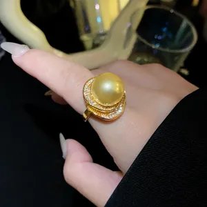 Gros plan d'une élégante bague en perle dorée avec un sertissage floral orné de zircons brillants