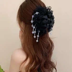 Détail d'une pince à cheveux en dentelle noire avec pampilles en cristal sur cheveux