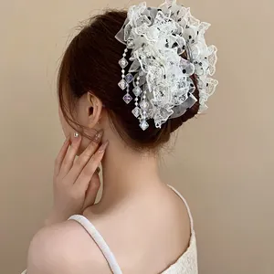 Détail d'une pince à cheveux en dentelle blanche avec pampilles en cristal