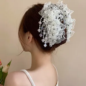 Vue détaillée d'une pince à cheveux en dentelle à pompons de style coréen pour chignon