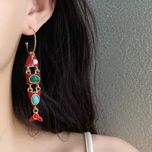Détail de la boucle d'oreille articulée en forme de poisson rouge aux pierres colorées