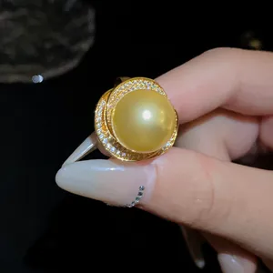 Gros plan d'une bague vintage en perle dorée avec détails de zircons étincelants