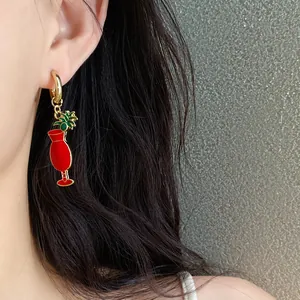 Détail rapproché d'élégantes boucles d'oreilles émaillées rouges en forme de cocktail