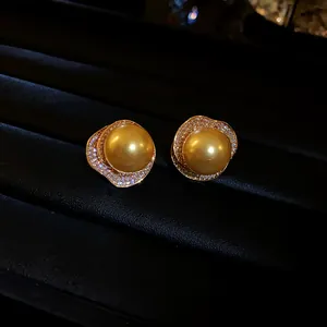 Boucles d'oreilles perles dorées élégantes avec halo de zircon sur velours noir