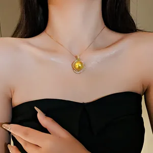 Gros plan d'un collier rétro français en or avec un pendentif perle jaune.