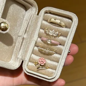 Close-up of a diverse ring collection with pearl, butterfly, and flower designs in a box