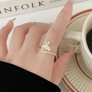 Close-up of elegant gold-tone butterfly open ring with zircon and shell-like inlay