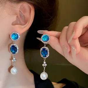 Close-up detail of vintage French style blue crystal and pearl drop earrings for women
