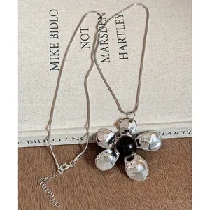 Primer plano de collar con colgante de flor de resina vintage con cadena de serpiente.
