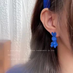 Minimalist Klein blue rabbit-shaped stud earring worn on ear showing retro aesthetic style