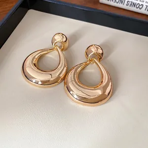 Boucles d'oreilles pendantes géométriques dorées avec une finition métallique polie