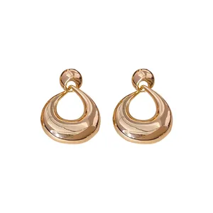 Élégantes boucles d'oreilles pendantes géométriques dorées au design creux minimaliste