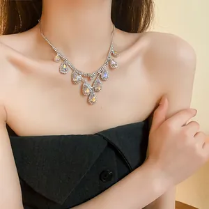 Sparkling teardrop crystal pendant necklace worn by model in elegant French style.