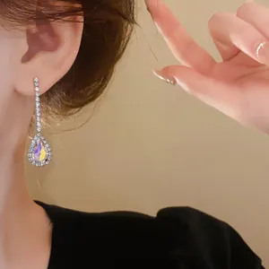 Detailed view of elegant French luxury teardrop rhinestone earrings worn by model