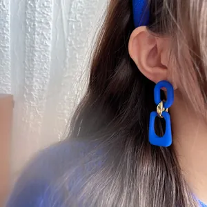 Detailed view of Klein blue vintage geometric dangle earrings worn by an Asian model