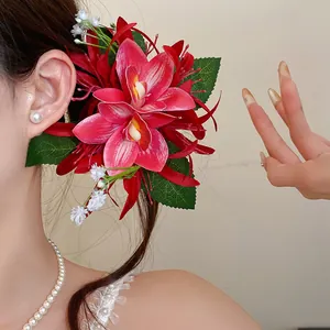 Close-up of elegant red and pink fabric orchid hair flower clip for a sweet forest style look.