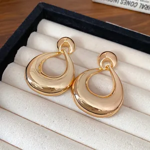 Gros plan détaillé de boucles d'oreilles géométriques dorées sur un plateau à bijoux en velours