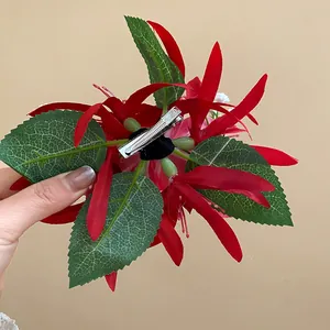 Close-up detail of the metal duckbill clip on the back of a red floral hair accessory.