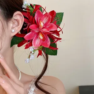 Close-up of a large red orchid fabric hair clip worn by a woman for a sweet forest style look.
