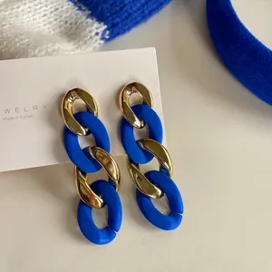 Close-up detail of Klein Blue and metallic gold interlaced chunky chain drop earrings
