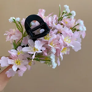 Detailed view of a sweet Mori style hair clip with multiple pink and white fabric flowers