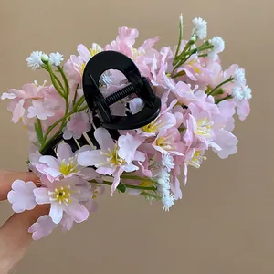 Close-up of a floral hair claw clip with delicate pink and white fabric flowers