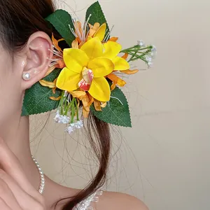 Detailed close-up of a sweet yellow fabric orchid flower duckbill hair clip worn on a model