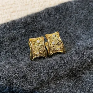 Orecchini geometrici dorati stile vintage con motivi floreali e diamanti incastonati